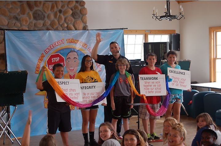 Photo Caption: The Sheriffs’ Summer Camp gives boys and girls from economically challenged circumstances an opportunity to experience all the traditional activities of summer camp while interacting with deputies from around New York State. Here a deputy conducts a character education workshop with a group of truly happy campers. The Sheriffs’ Summer Camp