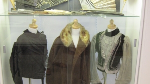 Attire from the mid 19th century and several antique fans